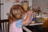 Julia thought she would lick the lid while Daddy was making malts